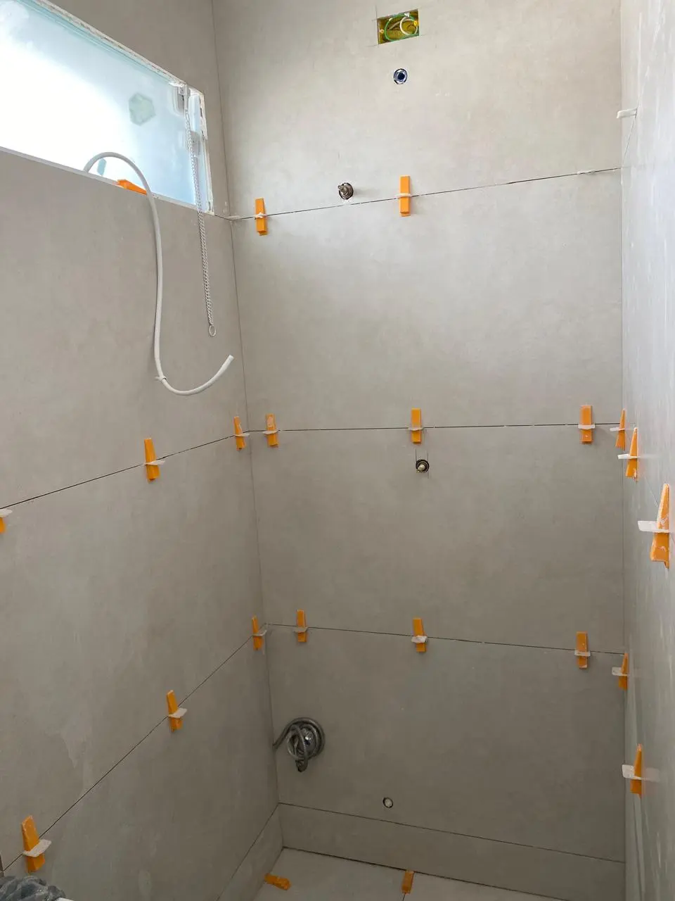 Box de banheiro com o porcelanato sendo assentado